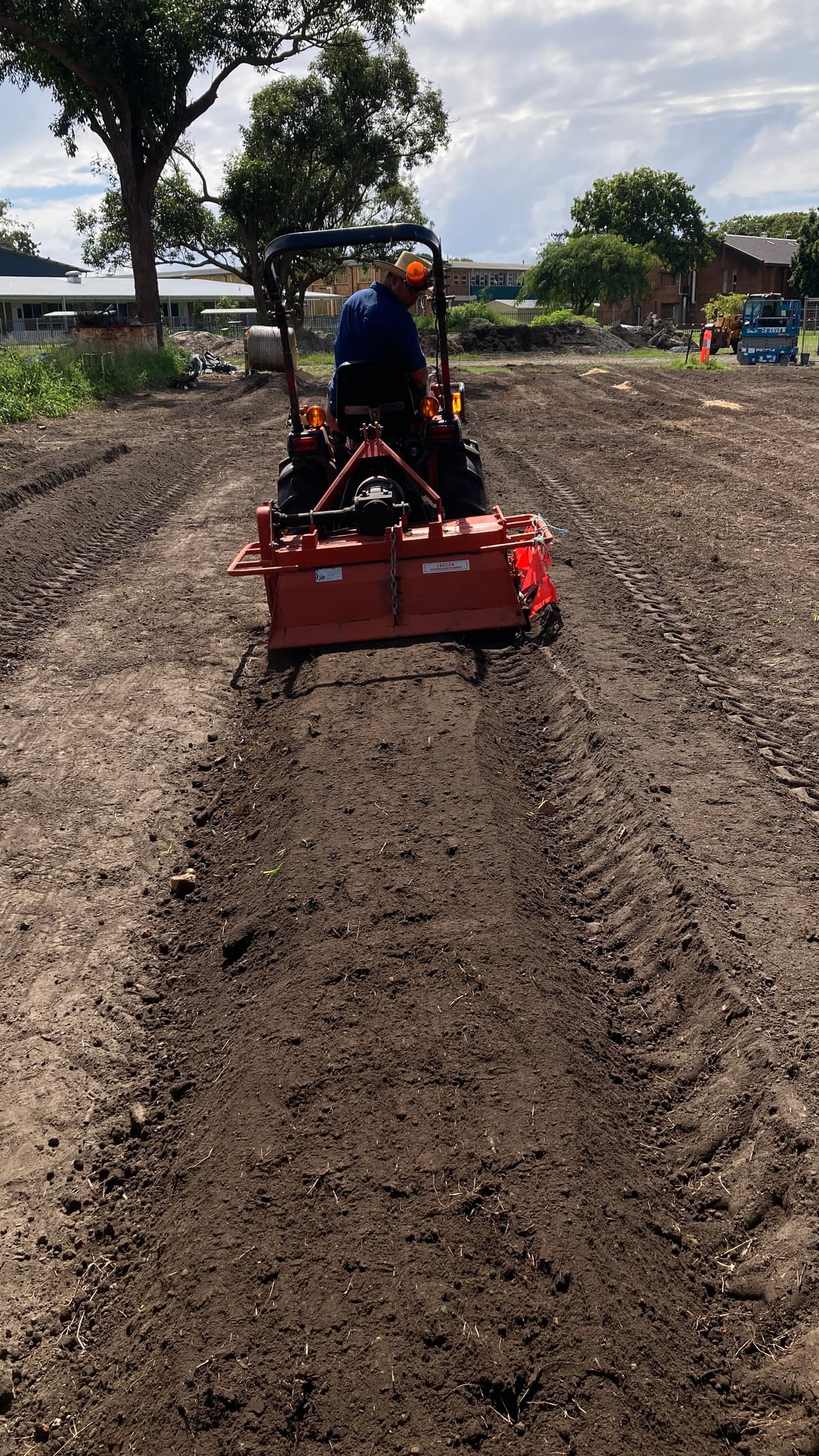 Small tractor forming beds in freshly turned soil